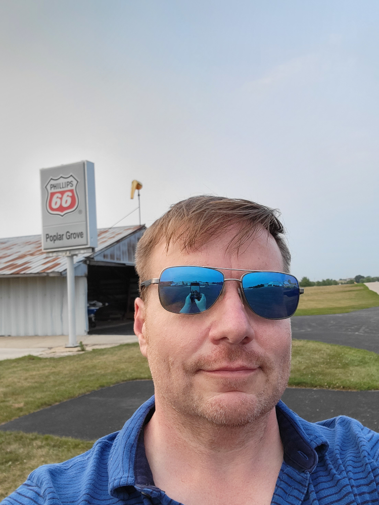 Zack-standing-in-front-of-the-Poplar-Grove-airport-sign